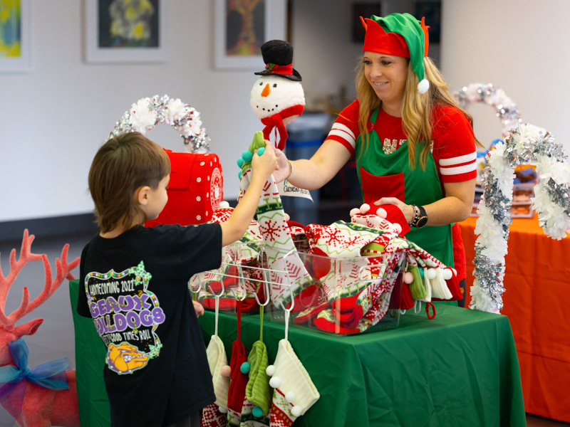 Children's of Mississippi patient Branson Canley of Mount Olive receives a Christmas stocking from Leslie Campbell, Friends of Children's Hospital community relations and special events manager. Melanie Thortis/ UMMC Communications 