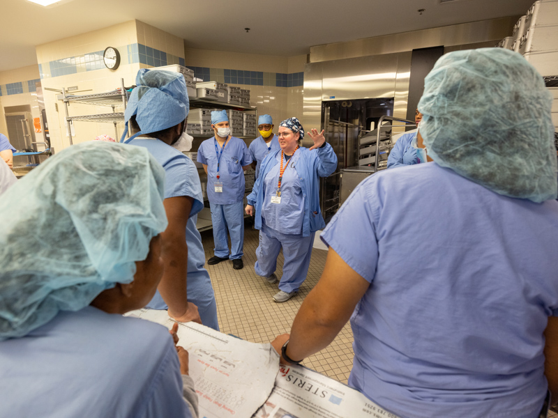 Sterile Processing director Kim Mekonis, center, updates employees during a standing five-minute conversation at shift change.