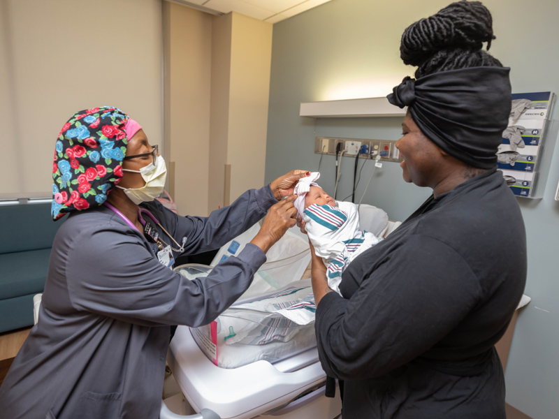 Registered nurse Annie Marshall checks on new mom Tierra Ralph of Jackson and daughter Aloria Ralph. Melanie Thortis/ UMMC Communications