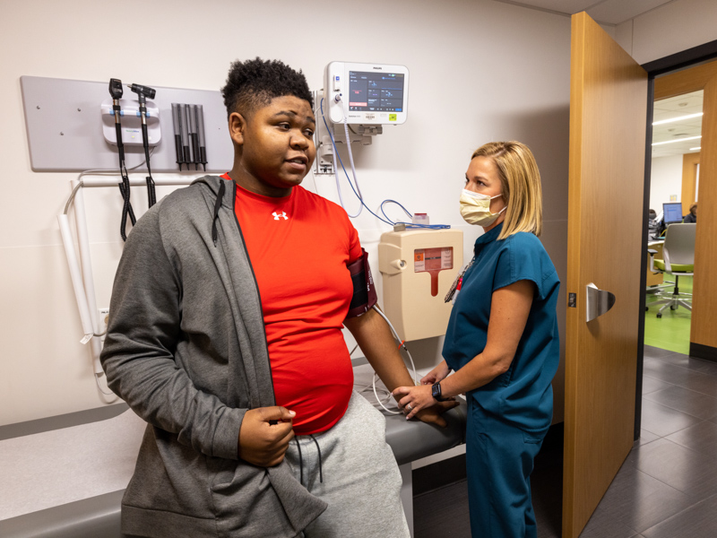 Patient Kaeden Thigpen of Hattiesburg talks with pediatric pain clinic RN-care coordinator Shannon Armstrong.