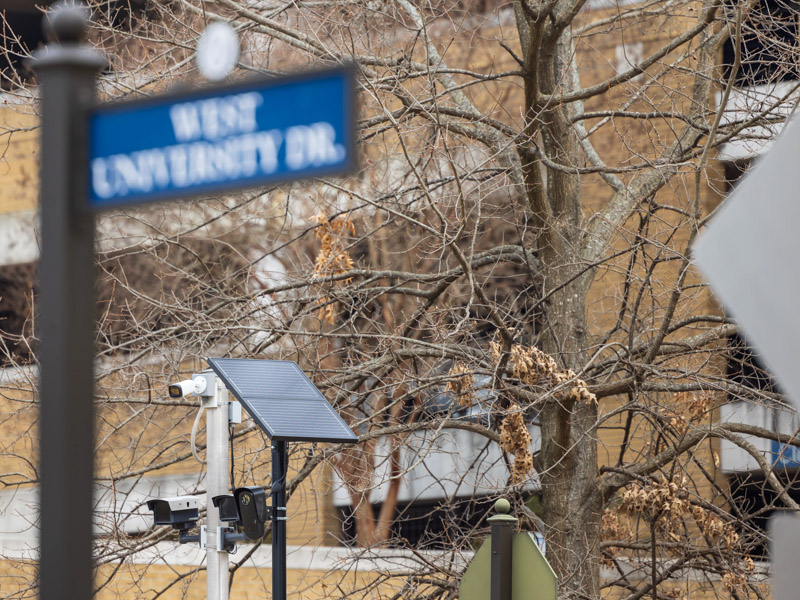 New solar-powered security cameras can be seen in front of University Hospital. The new models will eventually replace existing cameras seen at far left.