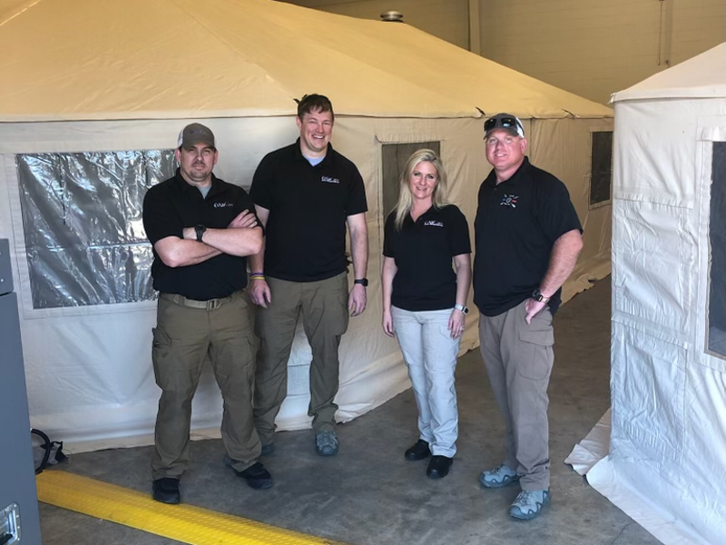 Taking a break from assembling and equipping UMMC’s mobile field hospital inside the National Guard Armory in Rolling Fork are, from left, AirCare critical care paramedic Kyle Upchurch; Will Appleby, Mississippi Center for Emergency Services critical care transport educator; and AirCare critical care paramedics Kaci David and Ron Hopson.