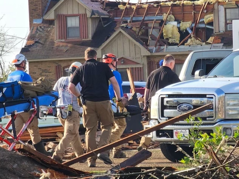 Mississippi Center for Emergency Services staff Will Appleby, center in black shirt, and Jeremy Benson, in black shirt to Appleby's right, help in search and rescue efforts at a Rolling Fork home.