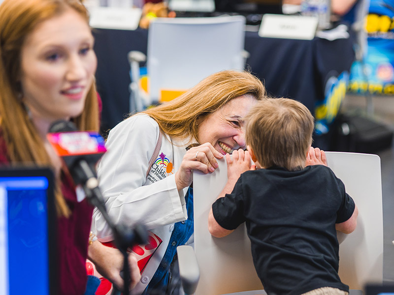 Dr. Jennifer Shores says hello to one of her patients, Ward Phillips of Madison, as his mom, Abbey, left, does a radio interview.