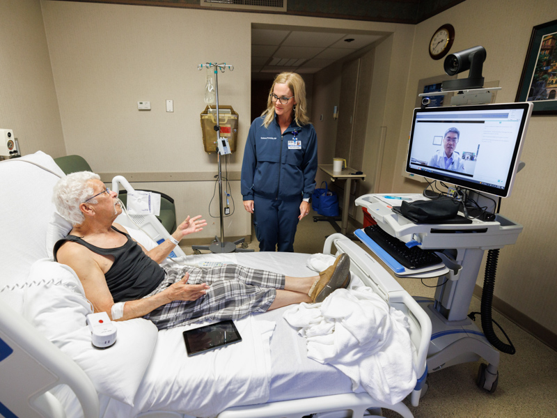 Delane Pressly, a neurology nurse practitioner at South Central Regional Medical Center in Laurel, facilitates a telehealth neurology evaluation between patient Michael Bustin and UMMC neurologist Dr. Juebin Huang.