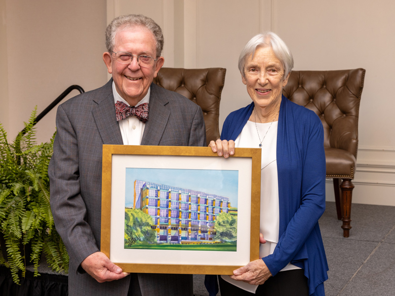 Dr. Rodney Meeks and Dr. Sara Meeks display a watercolor of the Winfred L. Wiser Hospital for Women and Infants, named for Rodney Meeks' mentor at UMMC. The painting was presented to the couple Thursday, following the announcement of the Drs. G. Rodney and Sara M. Meeks Endowed Chair in Obstetrics and Gynecology