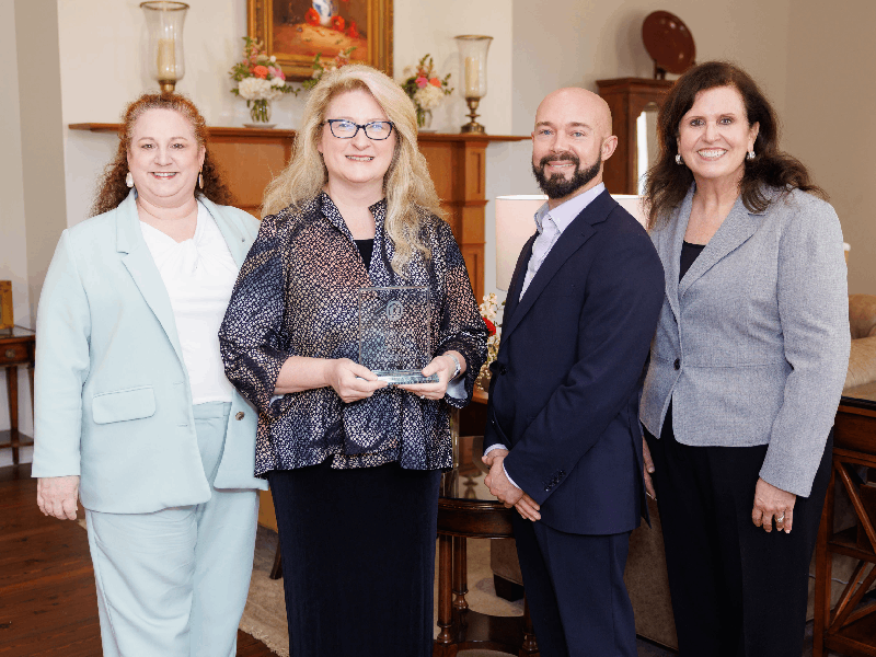 Dr. Amy Smith, second from left, Alumna of the Year, is congratulated by, from left, Michelle Goreth, president-elect of the UMMC School of Nursing Alumni Association; Michael Parnell, association president; and Dr. Julie Sanford, dean of the School of Nursing.