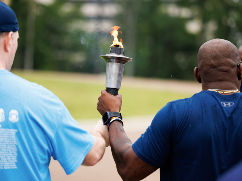 Special Olympian Brendan Leahy, of Chicago, left, and Capitol Police officer Jamal Watkins clutch the torch supporting the Flame of Hope.