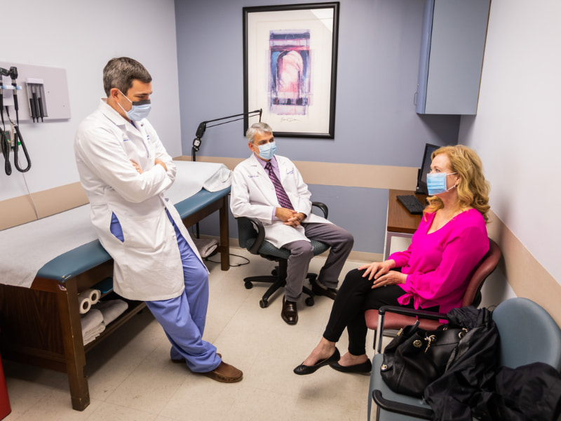 Dr. Chad Washington, left, and Dr. Shashank Shekhar chat with patient Judy Herrington during a clinic visit in 2020.