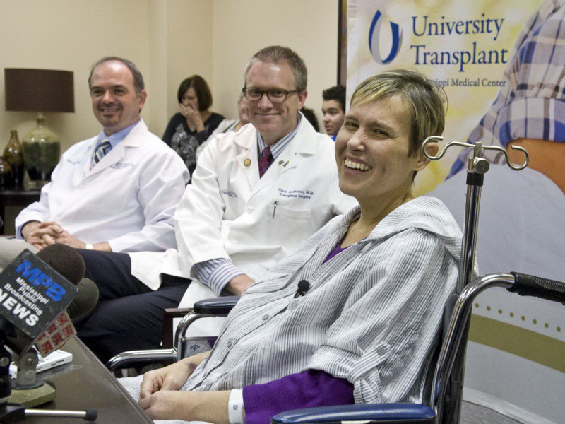 Karen Battle, with Dr. Chris Anderson, center, answers questions about her March 4, 2013 liver transplant surgery during a news conference several days later at UMMC.