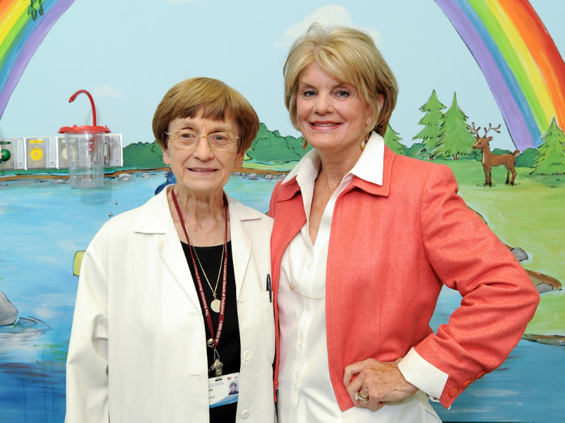 Dr. Jeanette Pullen and Suzan Thames smile under a rainbow mural after the opening of the Center for Cancer and Blood Disorders in this UMMC file photo.