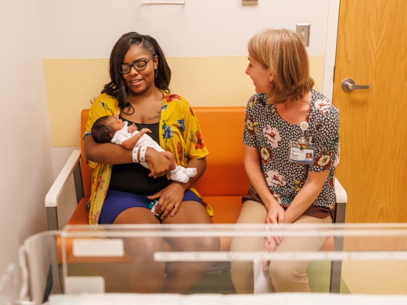 Takia Hampton of Jackson, cradling newborn daughter Isabella, talks with Dr. Leigh Campbell, director of the lactation clinic at Children's of Mississippi.