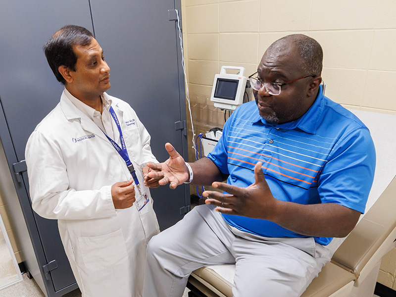 Dr. Garla, an endocrinologist, talks with patient Romal Bell, a participant in the FREEDOM clinical trial, during a recent visit.