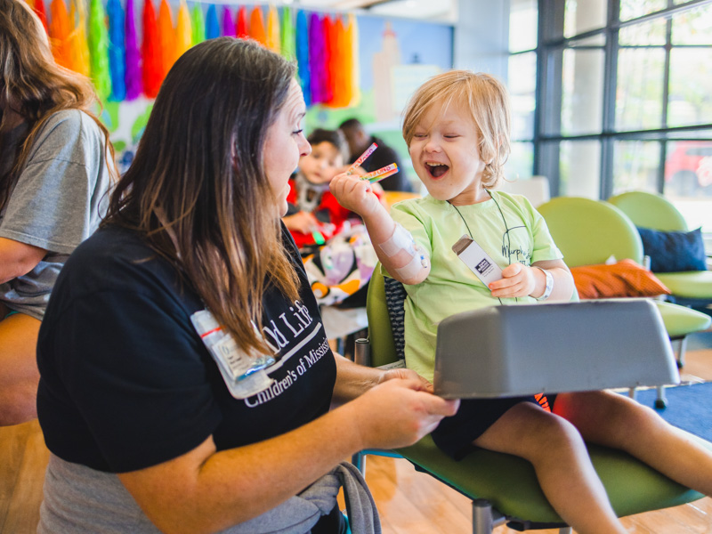 Children's of Mississippi patient Porter Antici of Madison shows child life specialist Pepper Weed-Cooper a handful of crayons.