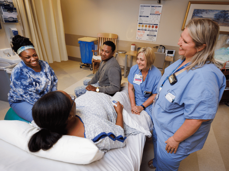 From left, UMMC Labor and Delivery Registered Nurse Ty Sims and Certified Nurse-Midwives Janice Scaggs and Kim Rickard provide care for Danielle Aguillard as she and her husband, Cortrel Horton, prepare for the birth of their son.