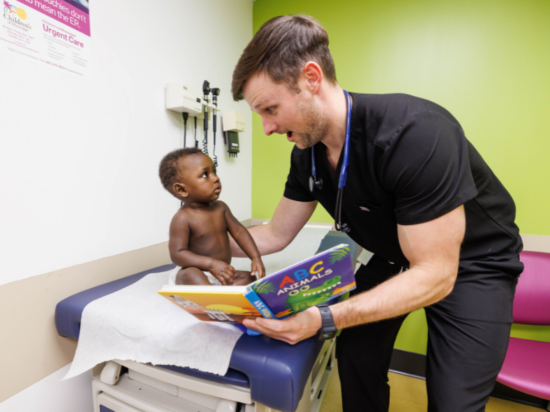Dr. Banks Carlisle, a UMMC pediatrics resident, reads to patient Bryson Nicholas of Jackson at the Batson Kids Clinic. Melanie Thortis/ UMMC Communications