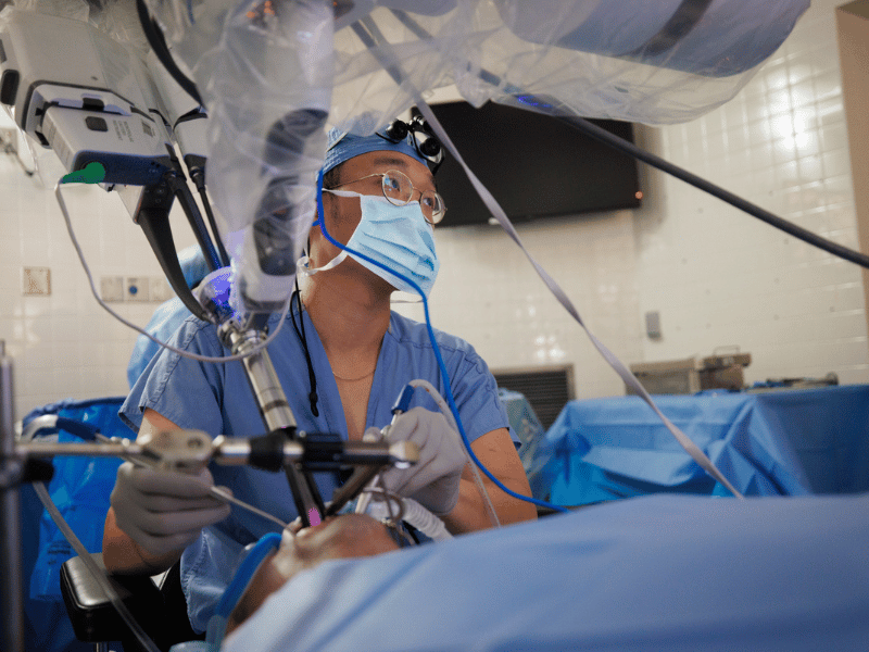 Otolaryngology resident, Dr. Jason Lee, assists head and neck surgeon, Dr. Anne Kane, perform one of the first Da Vinci SP robot-assisted oropharyngeal cancer operations in the state of Mississippi.