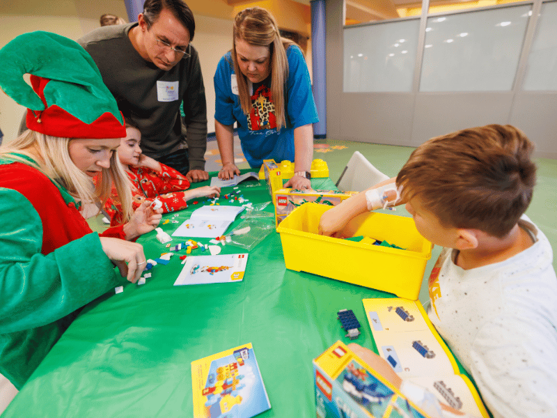 Working on Lego building projects are, from left, Hope Housel, senior project assistant with Brasfield & Gorrie, Emma Johanson with parents Jon and Christie Johanson of Brandon, and Eric Sharpe of Hattiesburg.