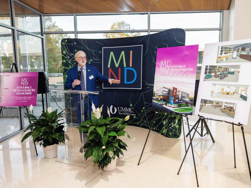 Dr. Mosley points to architectural renderings of The Fred R. Adams, Jr. MIND Center and Geriatric Clinic, a state-of-the-art facility that will span 30,000 square feet.
