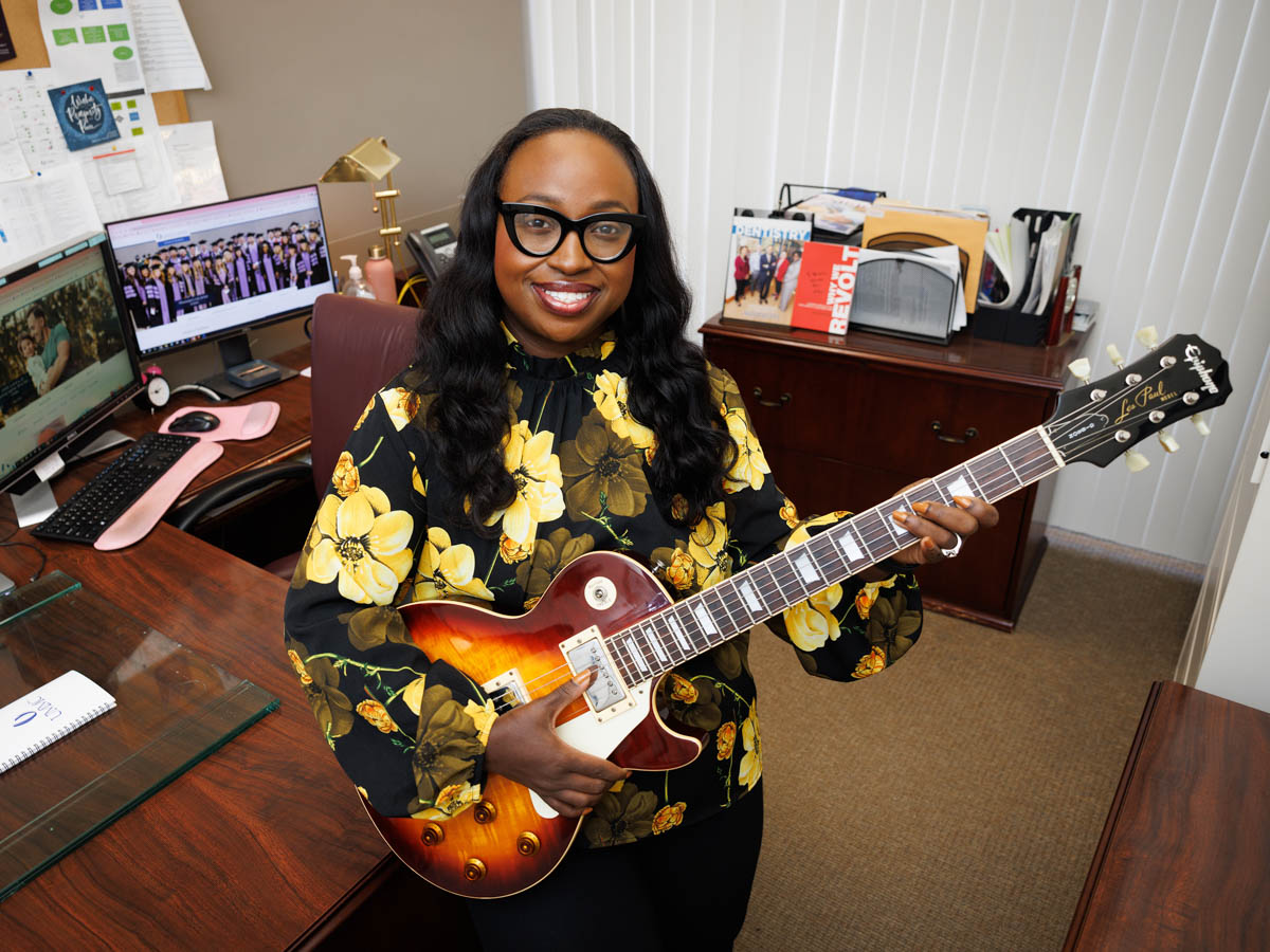 Venessia Randle poses in her office at the School of Dentistry with her first and favorite guitar that she bought when she was 17 years old.