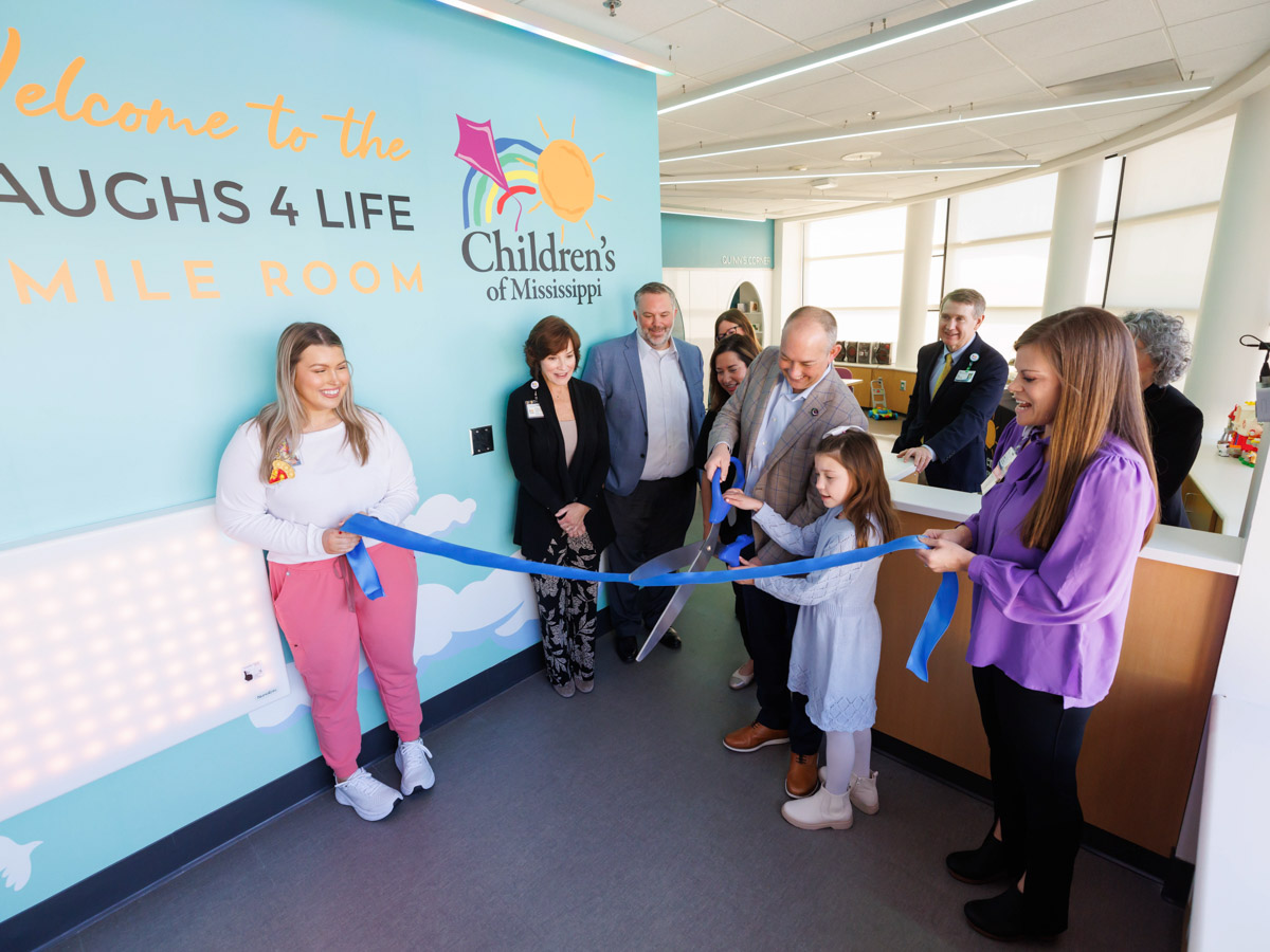 Kent Oliver and his daughter, Charlotte, 8, cut the ribbon for the Laughs 4 Life smile room at Children's of Mississippi.