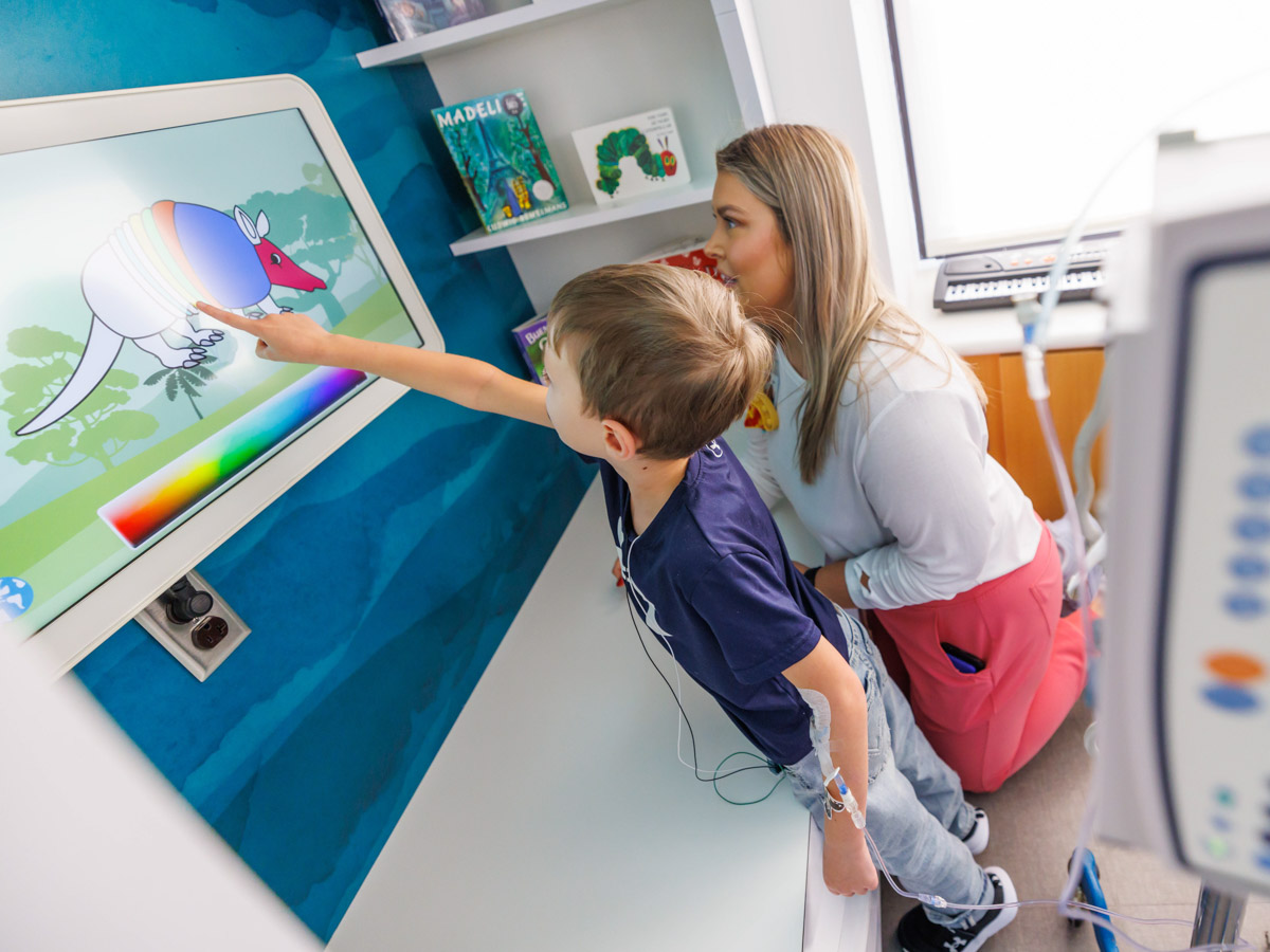 Children's of Mississippi patient Samuel Farve of Sumrall adds color to a creature while child life specialist Allyson Holliman looks on.