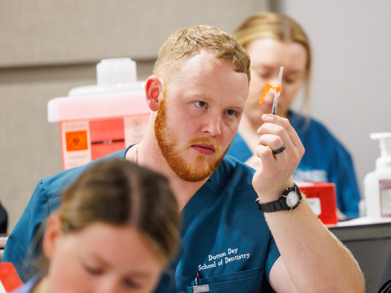 Second-year dental student, Dutton Day, preparing to learn how to administer a vaccine.