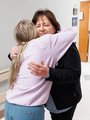 Pam Farris, nurse manager of Bone Marrow Transplant Unit, hugs Kaitlin Chesser, a registered nurse in the unit.