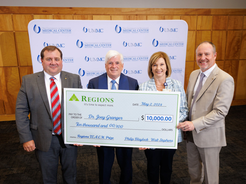 TEACH Prize awardee Dr. Joey Granger, center, professor of physiology and biophysics, and Dr. LouAnn Woodward, vice chancellor for health affairs and dean of the School of Medicine, are flanked by representatives of Regions Bank: Walt Stephens, left, and Philip Blaylock.