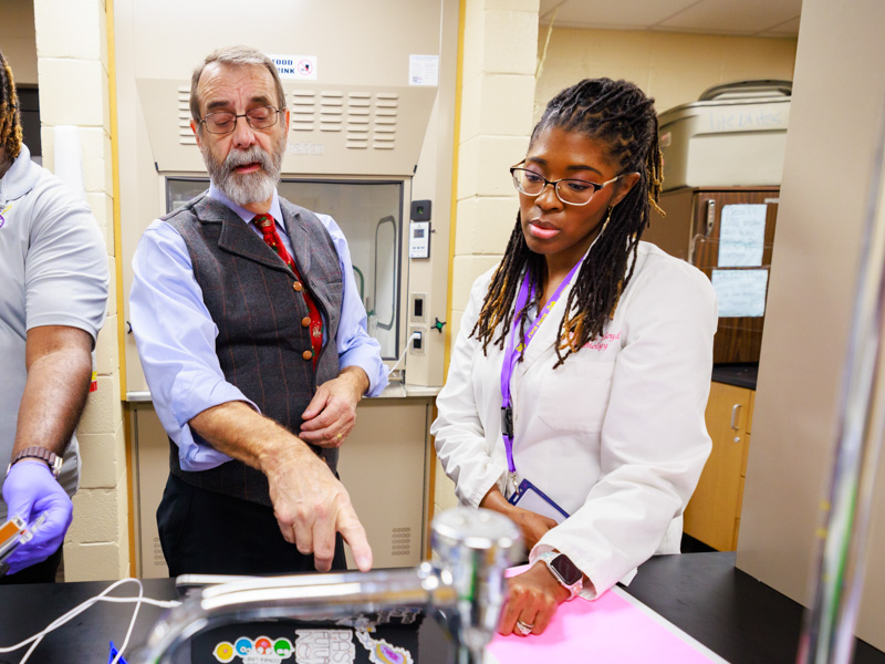 Base Pair founder Dr. Rob Rockhold and Hattiesburg High teacher and Base Pair leader Mariah Hawkins discuss students’ research in the high school laboratory.