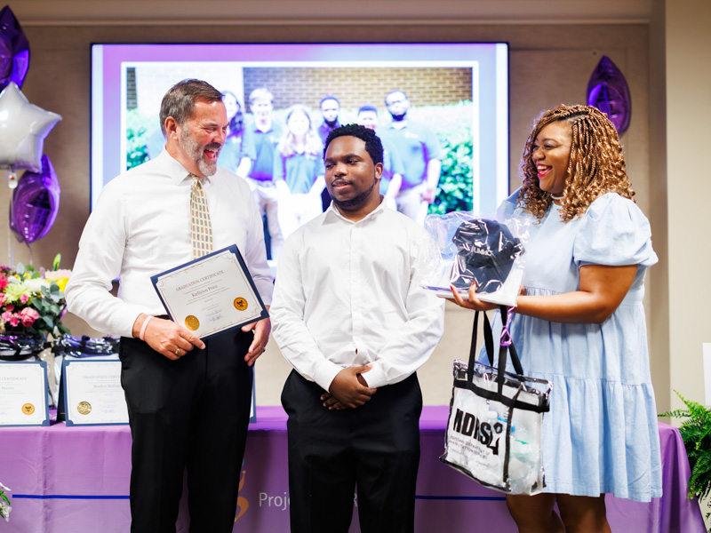 Congratulating 2025 Project SEARCH participant Karliyion Price, center, are Tommy Burnham, job skills trainer and Jasmine Lee, teaching assistant and job skills trainer.