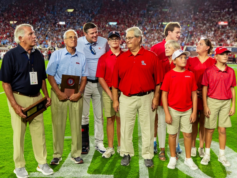 Johnny McRight, of Greenville, and James E. Poole Jr., of Jackson, were honored by the Ole Miss Chapter of the National Football Foundation and College Hall of Fame at the Sept. 13 Ole Miss vs. Arkansas football game. McRight was presented the Contribution to Amateur Football Award and Poole with the Distinguished American Award. Pictured here are, from left, Poole; Richard Noble of Indianola, president of the Ole Miss chapter; Keith Carter, vice chancellor of intercollegiate athletics; and the McRight family — grandson Joseph Nipper, McRight and wife Renee, grandson Christian Britt, daughter Meriwalker Nipper and grandsons Collins and Hall Nipper.