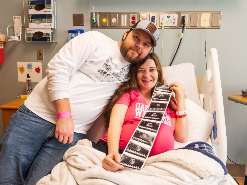 Shawn and Haylee Ladner of Purvis smile with some of their quintuplets' first "photos," images from a sonogram.