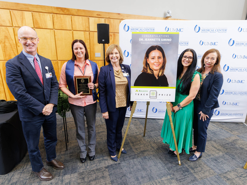 Dr. Jeannette Simino, second from left, the 2026 Regions Bank TEACH Prize honoree, is congratulated by, from left, Dr. Scott Rodgers, associate vice chancellor for academic affairs; (Simino); Dr. LouAnn Woodward, vice chancellor for health affairs and dean of the School of Medicine; and Regions Bank vice presidents Tamicalyn Foster and Regina Fowler.