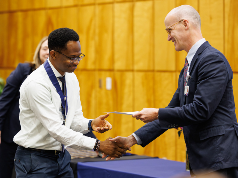 McKing Amedari, a 2025–2026 Honors College member in the John D. Bower School of Population Health, receives his certificate of completion of the program from Dr. Scott Rodgers, associate vice chancellor for academic affairs.
