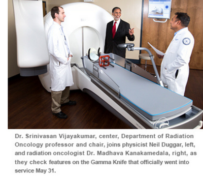 Dr. Srinivasan Vijayakumar, center, Department of Radiation  Oncology professor and chair, jo ins physicist Neil Duggar, left, and radiati on oncologist Or. Madhava Kanakamedala, right, as they check featt.a"es on the Gamma Knife that officially went into service May 31.