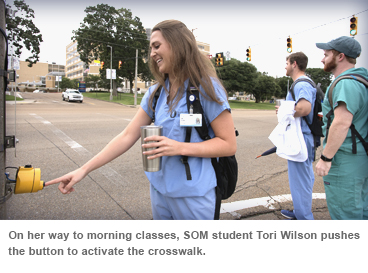 On her way to morning classes, SOM student Tori Wilson pushes the button to activate the crosswalk.