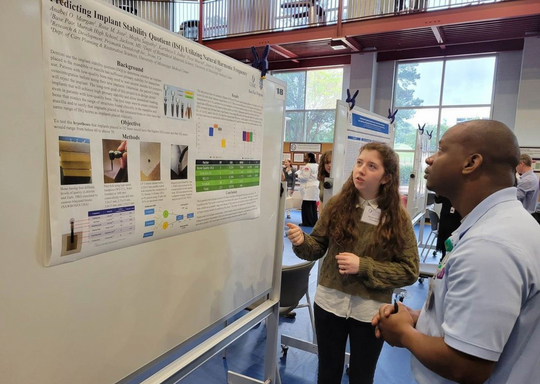 Two students looking at a research presentation display.