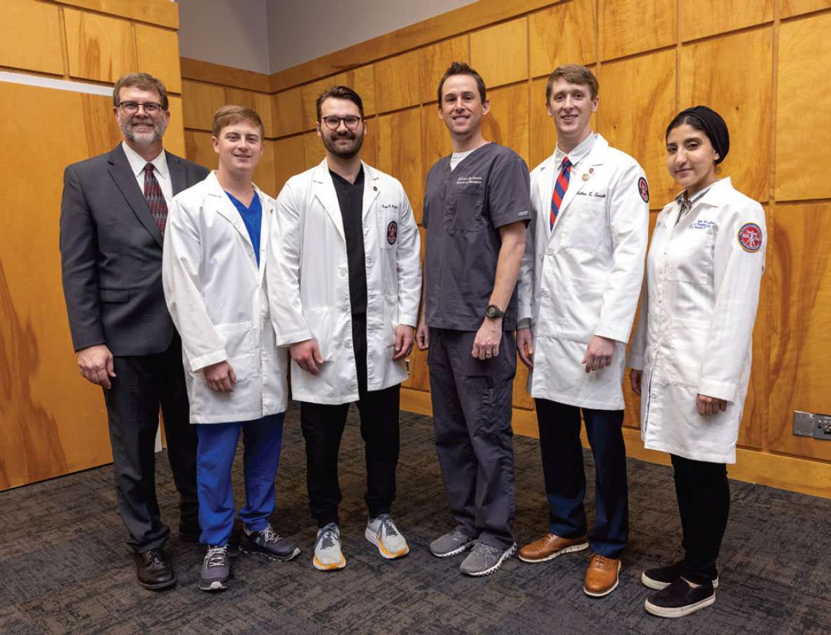 Dr. Jason Griggs poses with five graduate students.