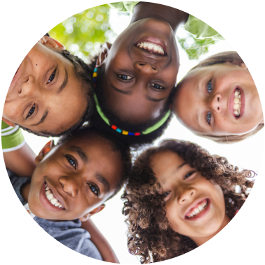 Circle inset of five smiling children standing in a circle from above. Outdoor background.