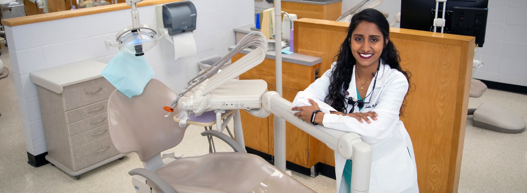Smiling dentist in front of dental equipment
