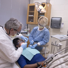 School of Dentistry faculty member examines a patient's mouth