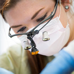 Close-up of a resident's face as she examines a patient