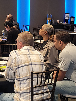 Crowd shot of conference attendees sitting at a table.