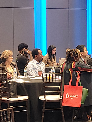 Crowd shot of seated attendees at a presentation.