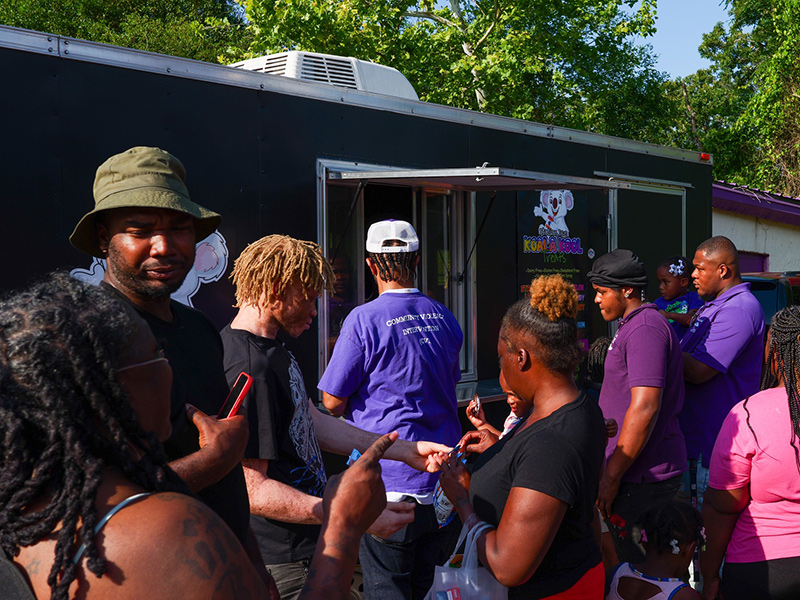 Outdoor crowd in line at a food truck.