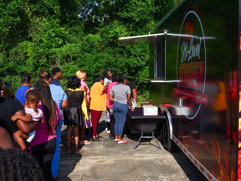 Attendees wait in line at a food truck.