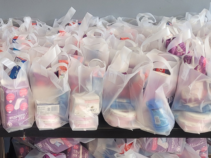 Closeup of giveaway bags with assorted toiletries.