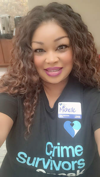 Michelle Brassfield wearing a Crime Survivors Speak Mississippi shirt and name badge.