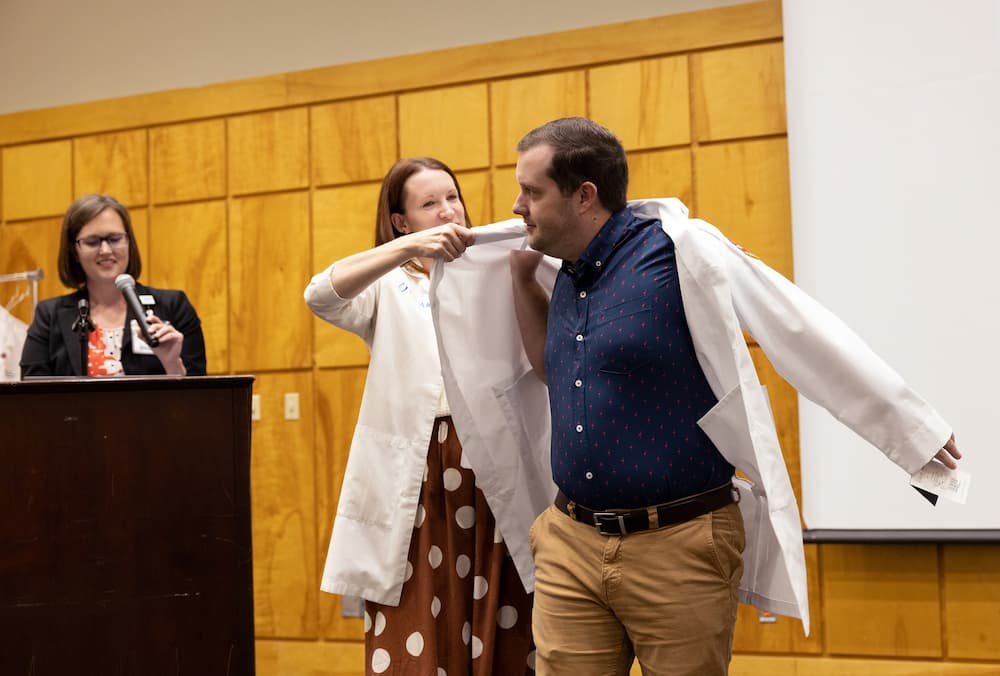 Photo of Matthew Byrd receiving his lab coat.